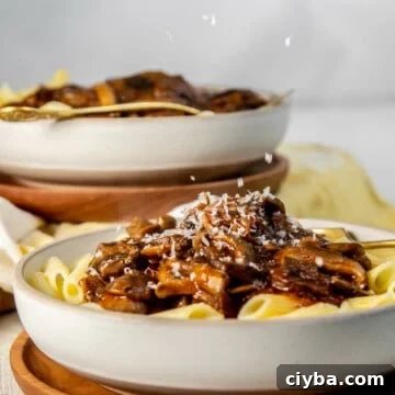 sprinkling cheese on a bowl of Mushroom ragu
