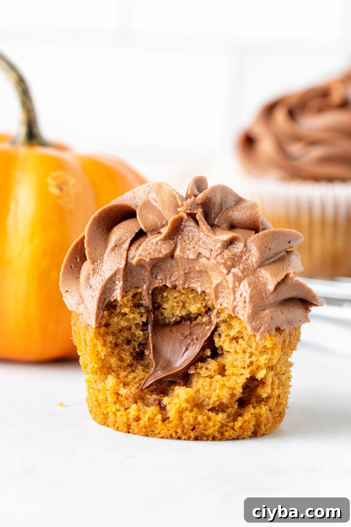 Nutella Pumpkin Cupcakes Recipe with Spiced Cream Cheese Frosting 2 Nutella pumpkin cupcake stuffed with Nutella with a bite taken out