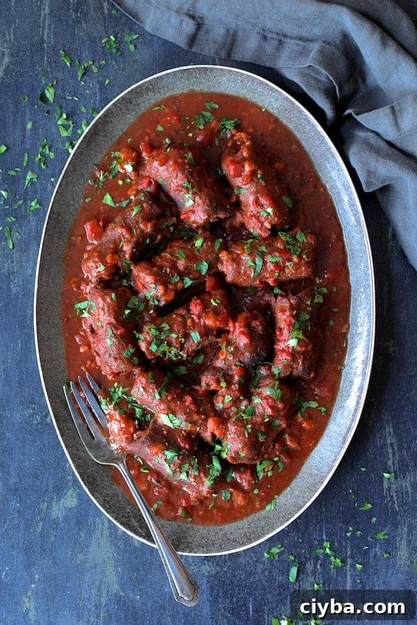 Rolled beef in tomato sauce topped with fresh herbs.