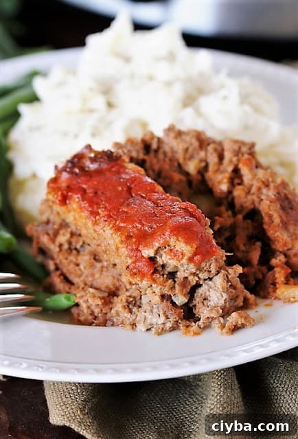 Meatloaf topped with tomato sauce on a plate.