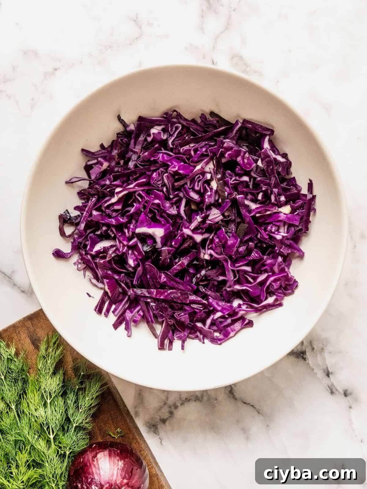 Crisp Purple Cabbage Slaw with Apple and Walnut Crunch 5 Shredded purple cabbage in a bowl.