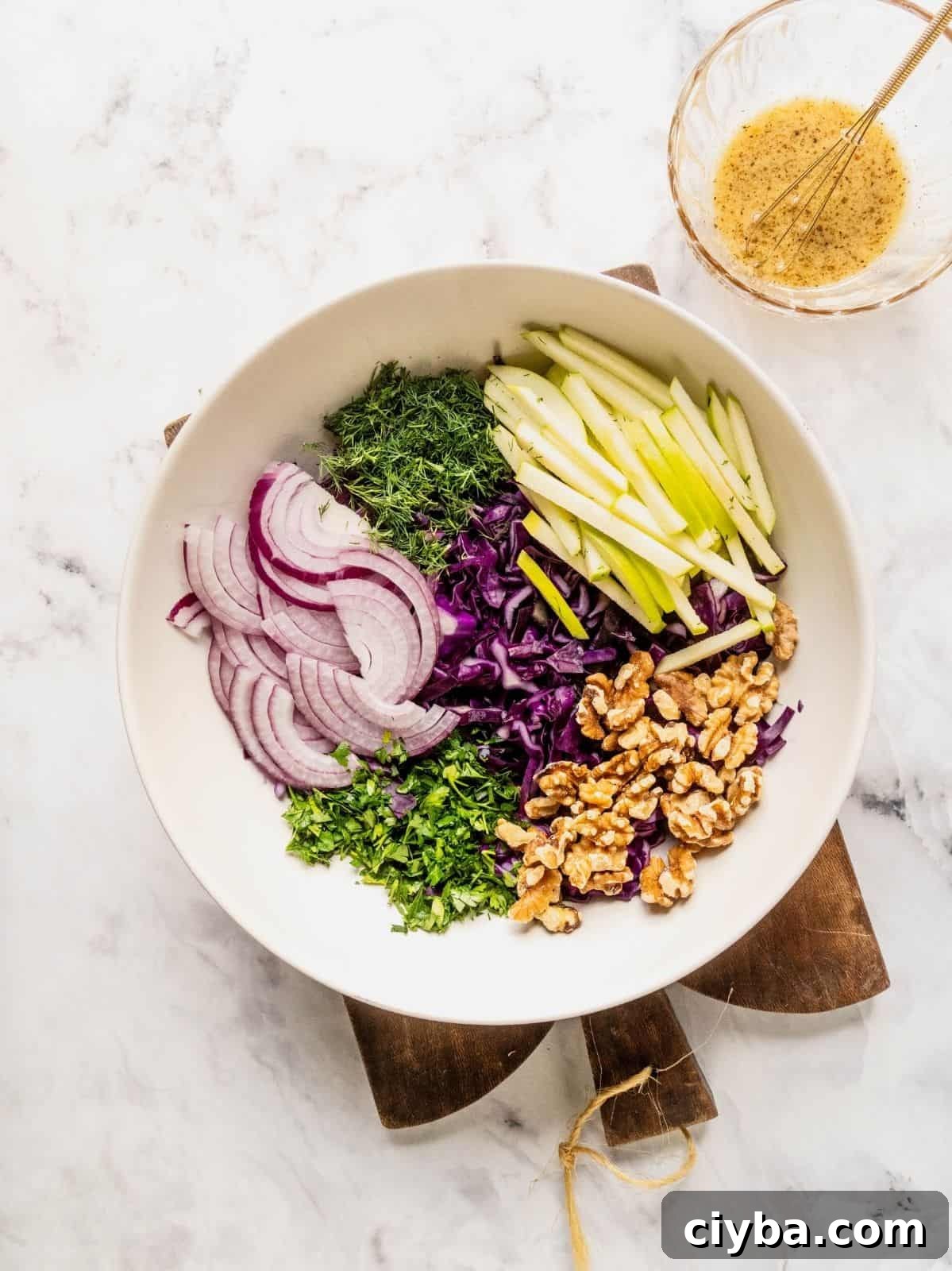 Crisp Purple Cabbage Slaw with Apple and Walnut Crunch 7 Bowl with sliced red cabbage, apples, onions, herbs and walnuts.