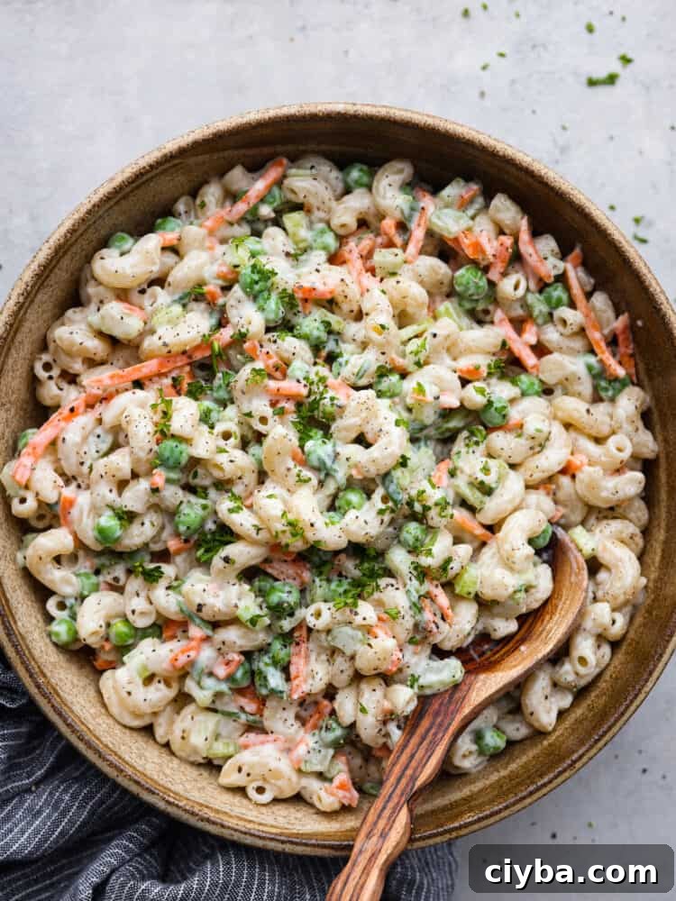 Top-down view of macaroni salad in a wooden bowl.
