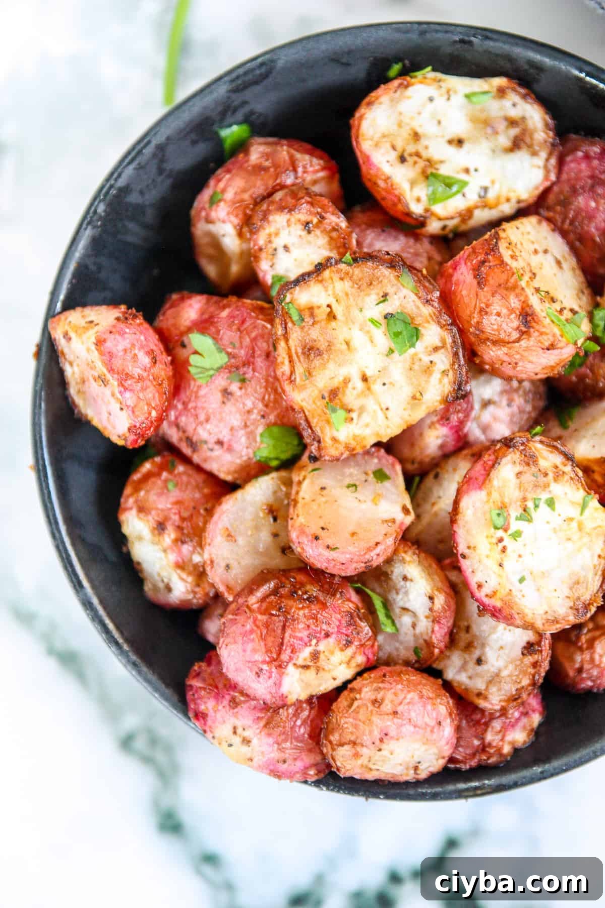 Air fryer radishes in a black bowl.