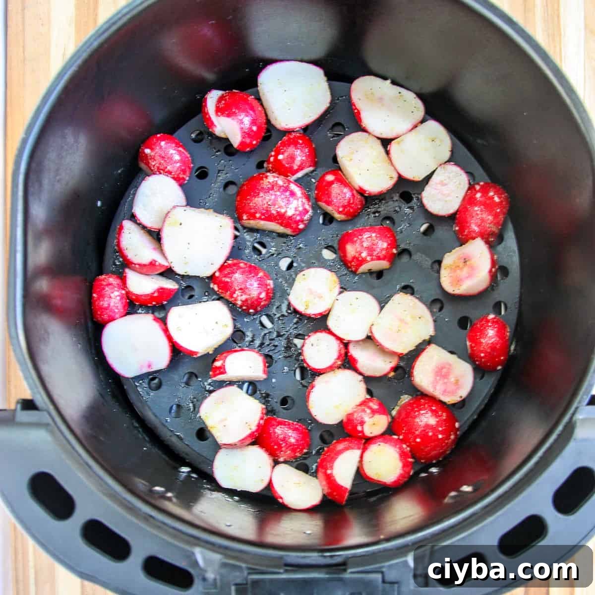 Seasoned radish slices in the air fryer basket ready to be cooked.