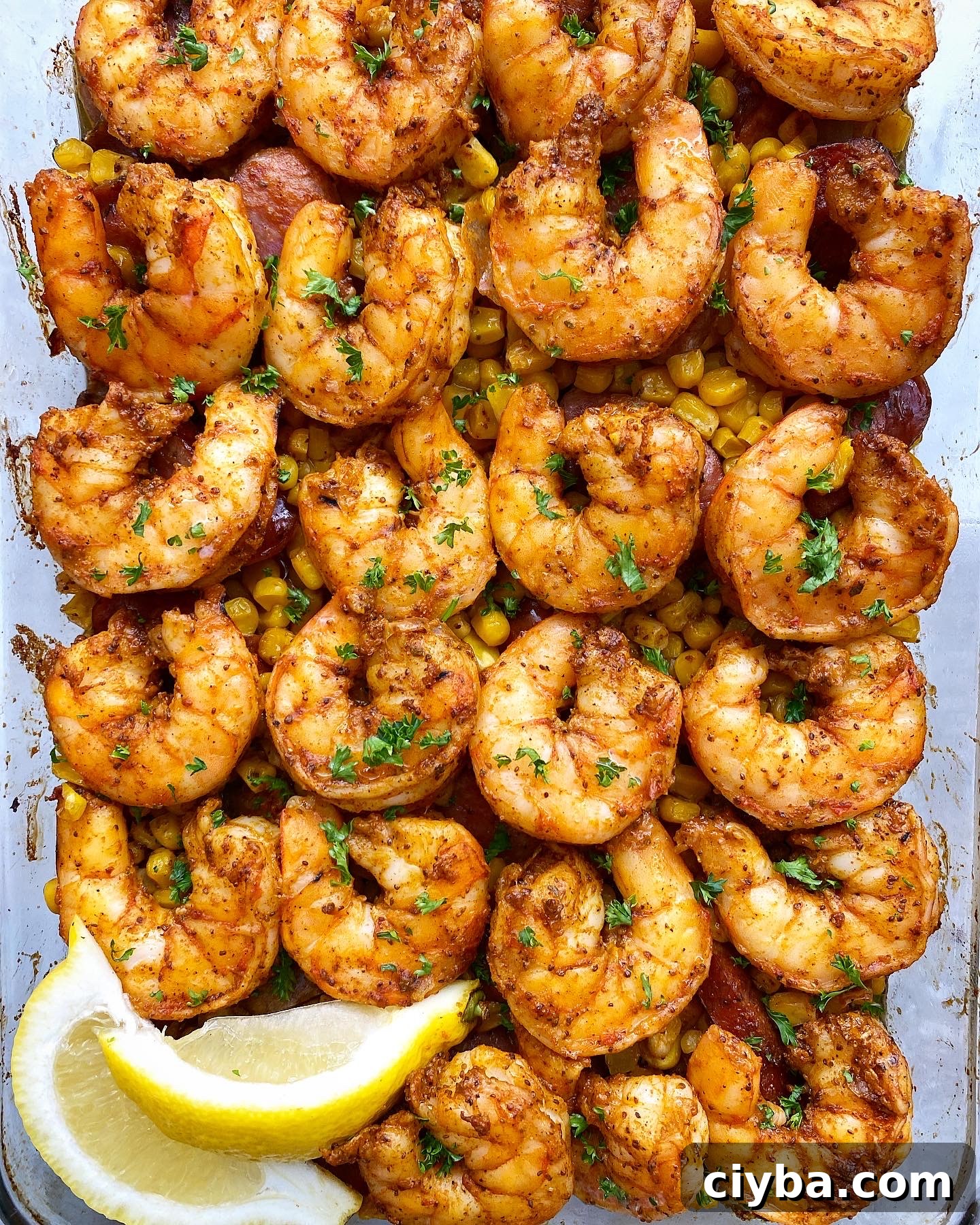 overhead close up shot of baked shrimp boil casserole in a clear baking dish