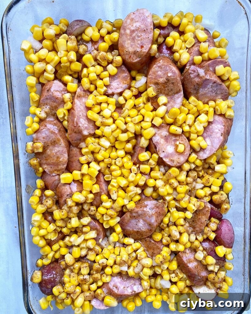 potatoes, sausage, onion, and corn in a casserole dish