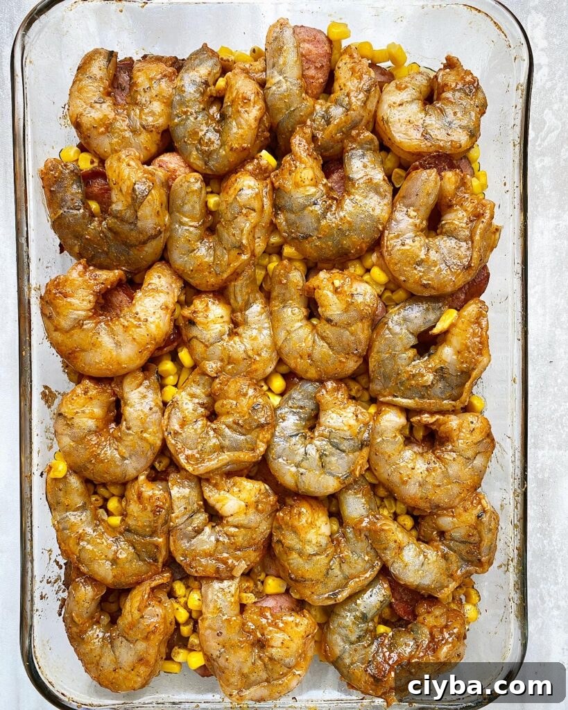 shrimp boil casserole with uncooked shrimp on top