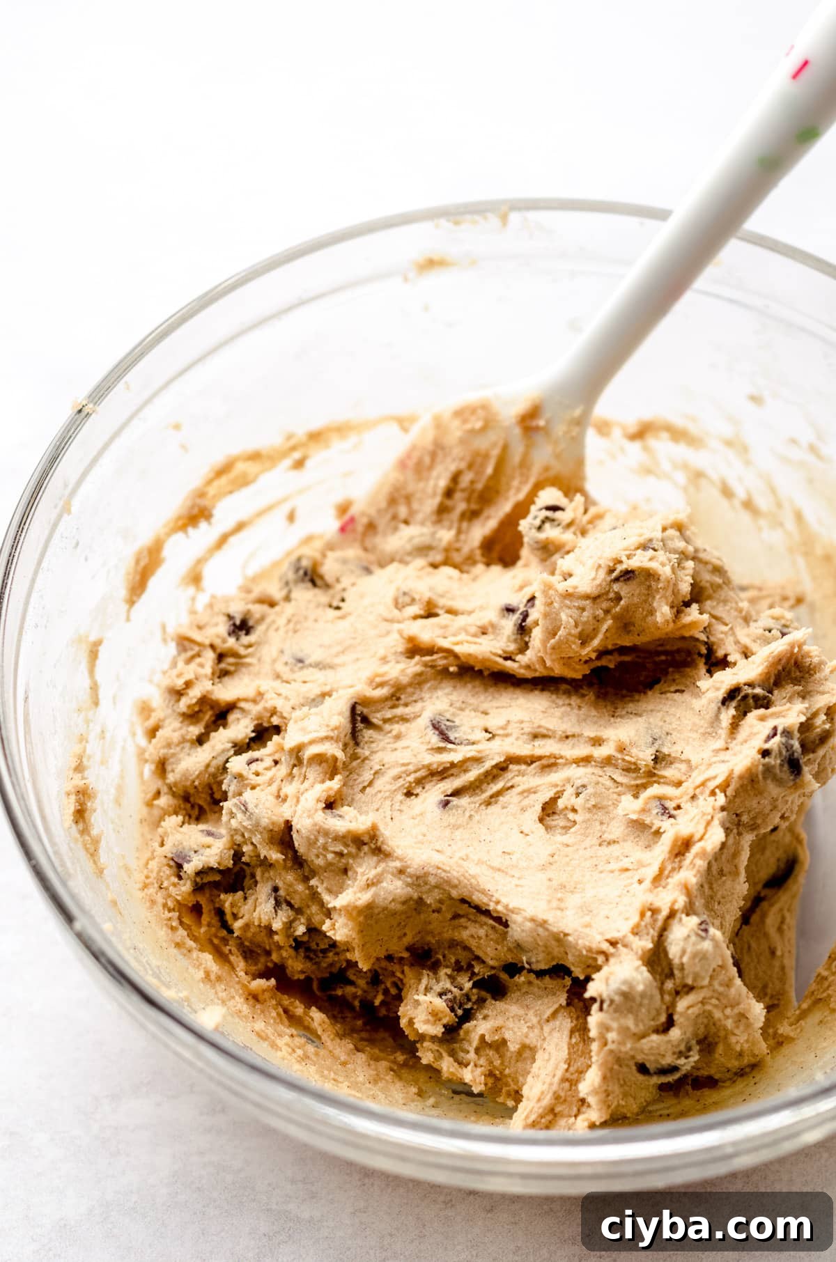 A bowl of base cookie dough with a silicone spatula inside.