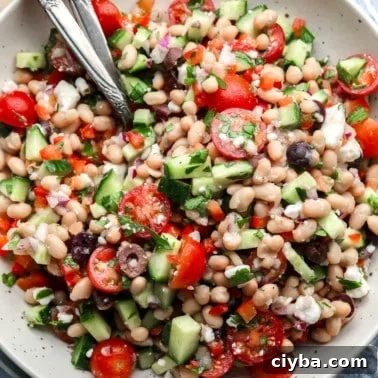 a Mediterranean white bean salad in a large white bowl.