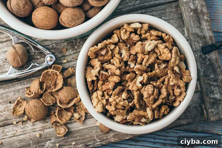 cracked walnuts in a bowl with shells on the table