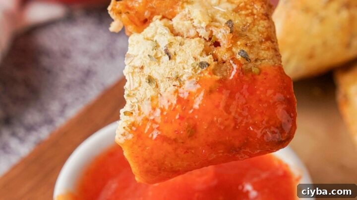 A Gluten-Free Pizza roll being dipped into a sauce.