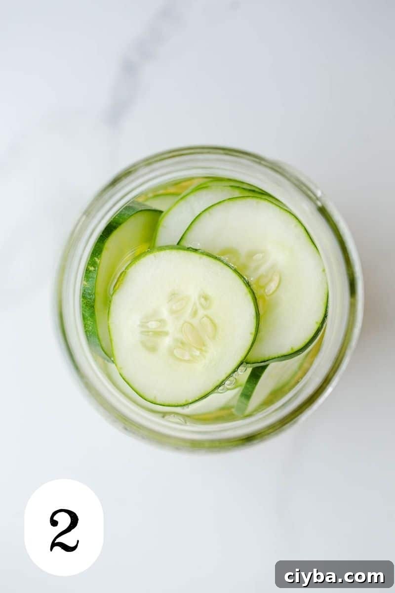 A jar with sliced cucumbers in liquid.