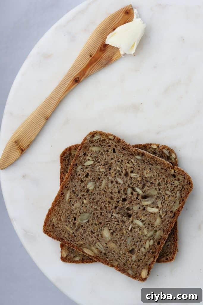 Rye bread on a plate with a wooden knife and butter