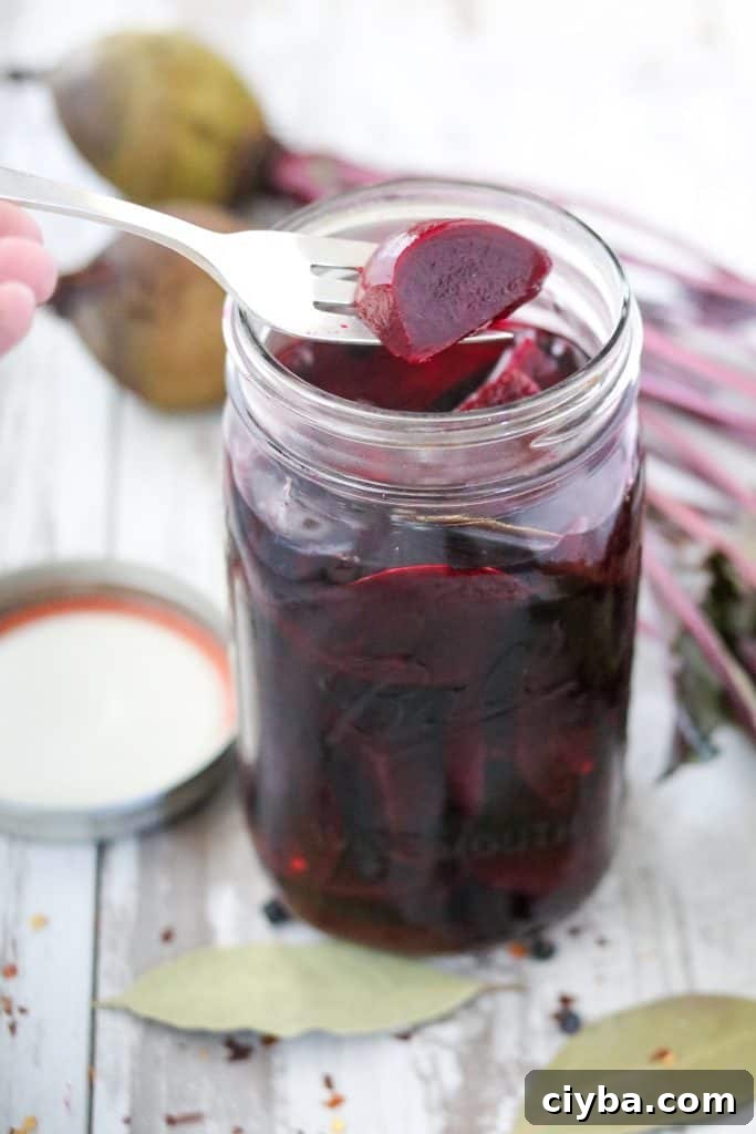 A jar filled with pickled beets and a fork