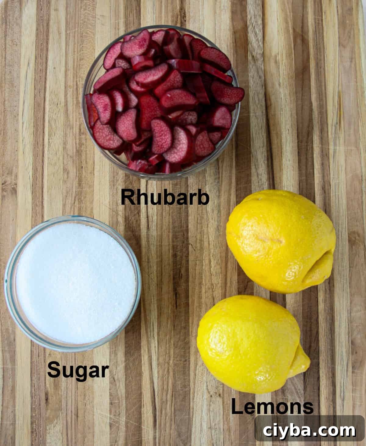 The ingredients for making rhubarb lemonade on a wooden board.