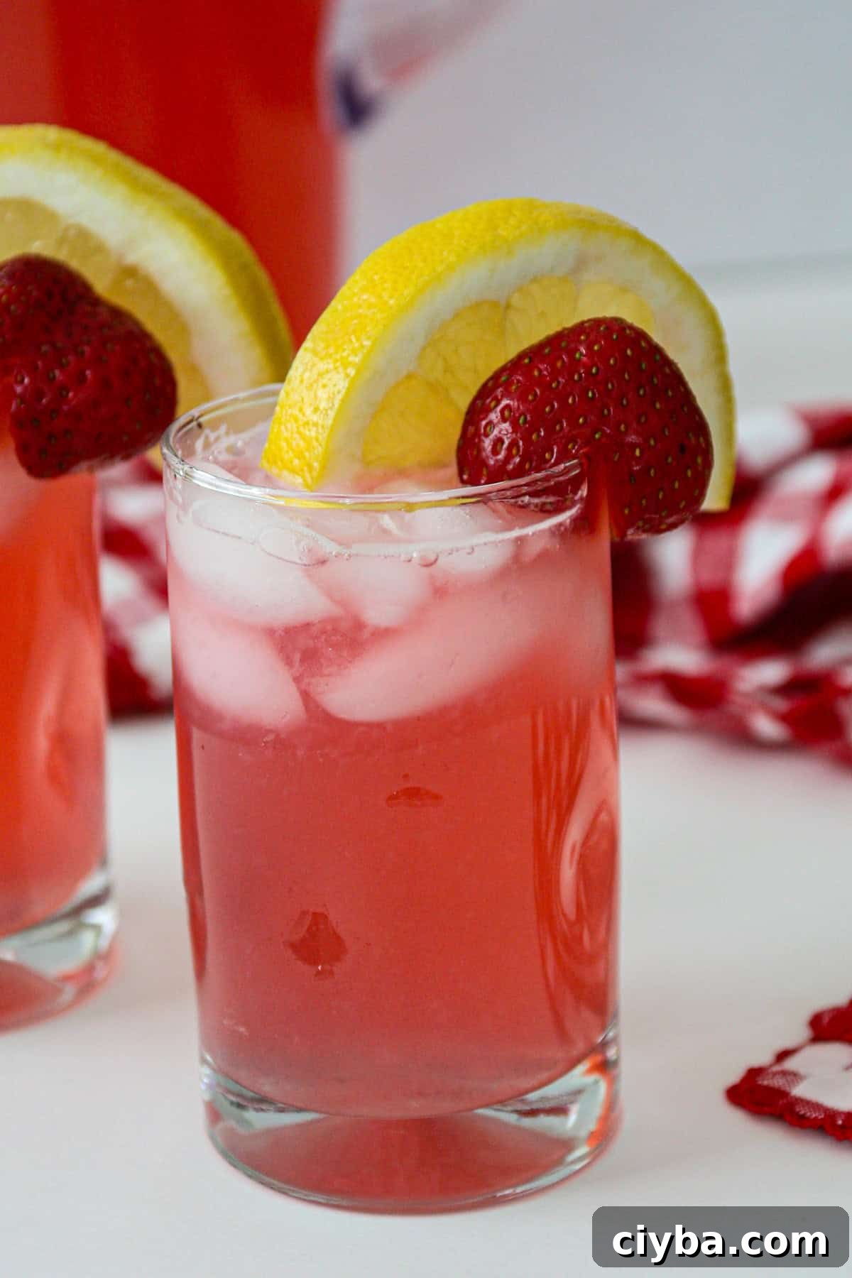 A glass of rhubarb lemonade topped with a slice of lemon.