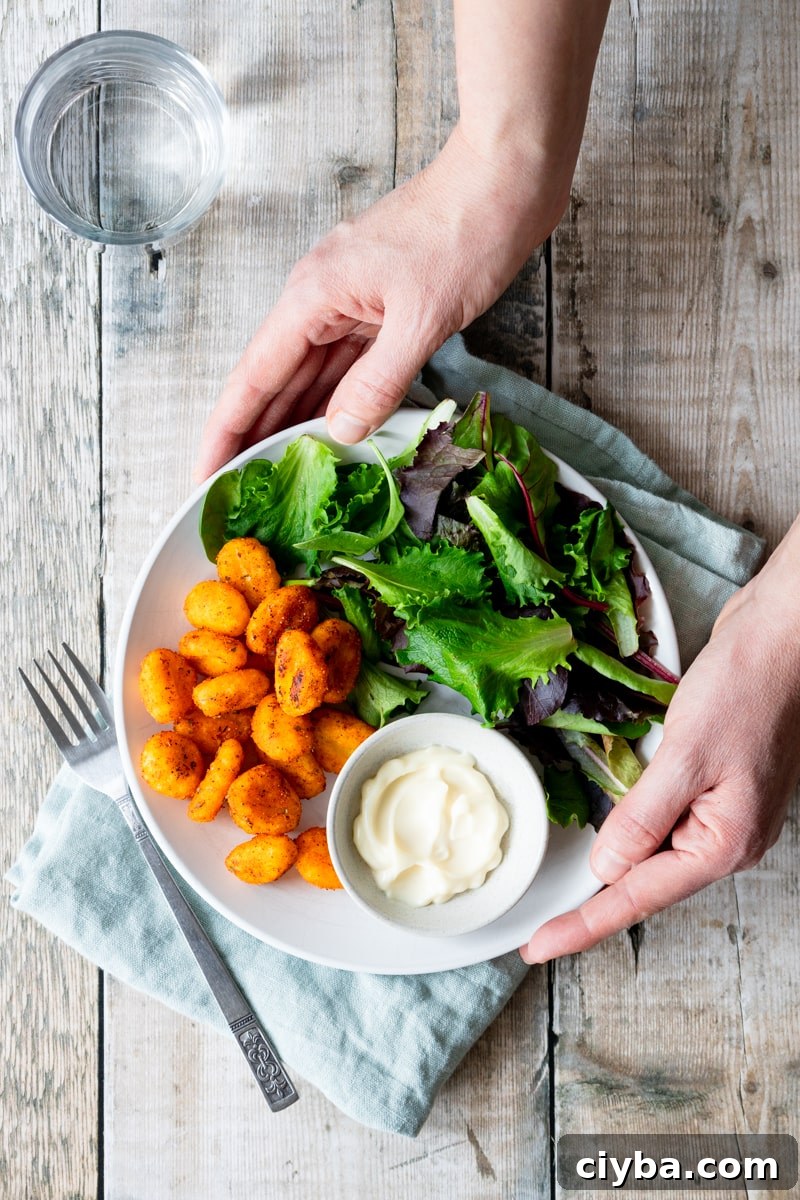 hands holding plate of air fried crispy gnocchi