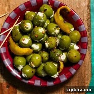 A bowl of blue cheese stuffed olives on a cutting board with toothpicks.