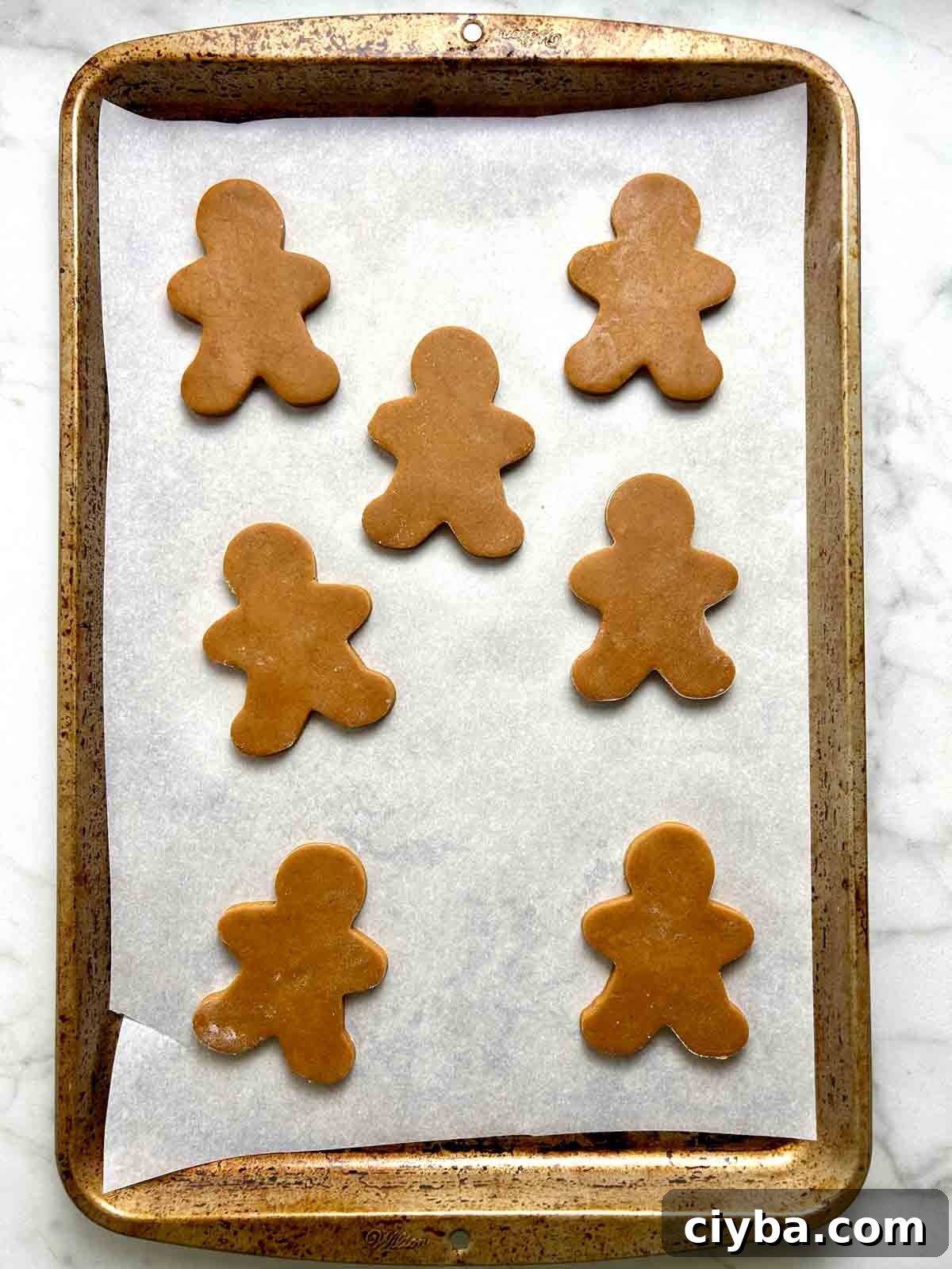 Classic Gingerbread Cookies Recipe for Soft, Spiced Cookies 9 cut out dough arranged in baking sheet.