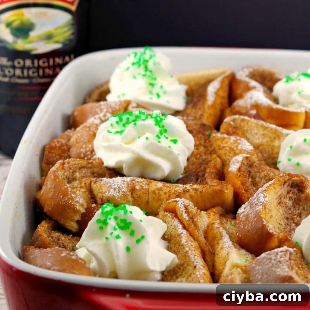 10 Irresistible Baileys Dessert Recipes for St. Patrick’s Day 13 bailey's French Toast Casserole in white and orange dish with bottle of Bailey's Irish Cream in the background