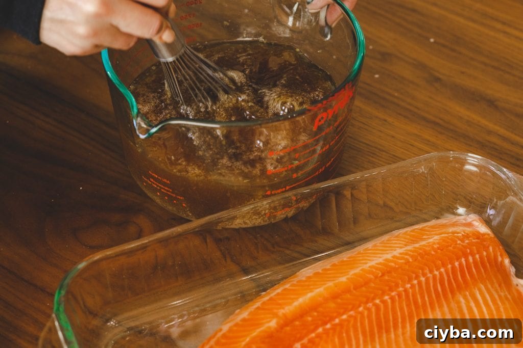 Salmon brine being whisked in a large glass bowl.