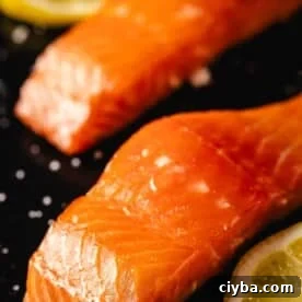 Smoked salmon filets with lemon wedges and salt sprinkles.
