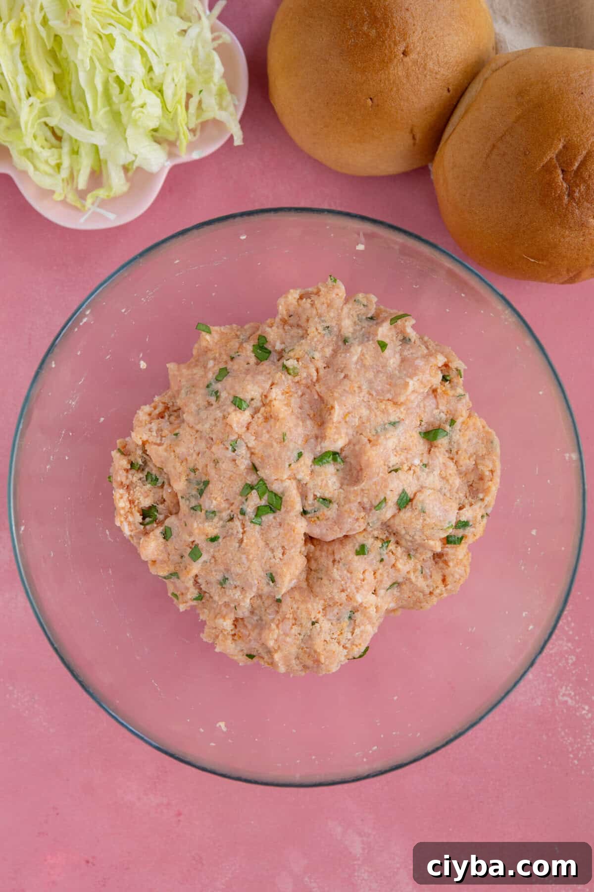 Process shot for chicken mince burgers showing the mixture combined together in a glass bowl.