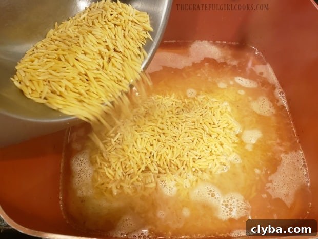 Orzo cooking in chicken broth