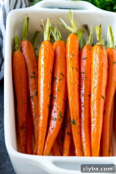 Honey roasted carrots in a baking dish, garnished with chopped parsley.