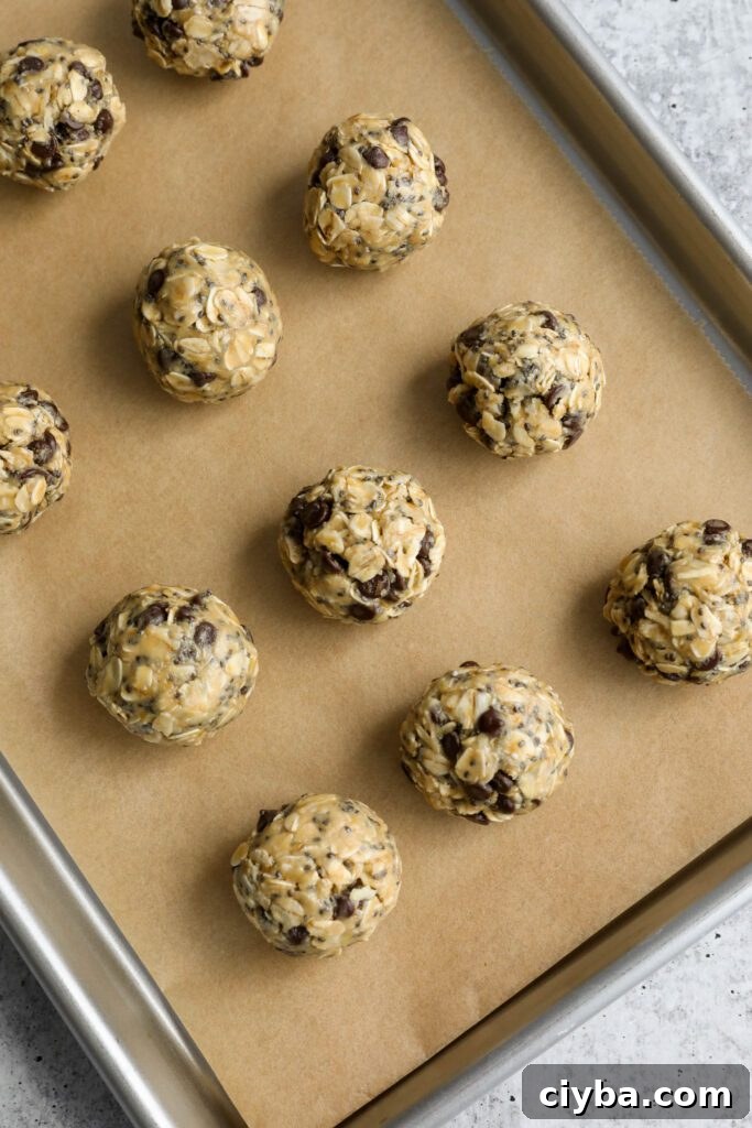 Tahini Chocolate Chip Bliss Balls rolled on parchment lined baking sheet