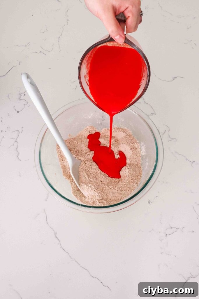 Red Velvet Cupcakes with Cream Cheese Frosting Recipe 5 The liquid red velvet ingredients are poured into a glass bowl with the dry ingredients.