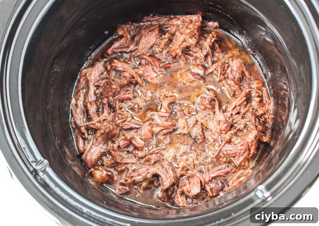 cooked and shredded beef in a slow cooker