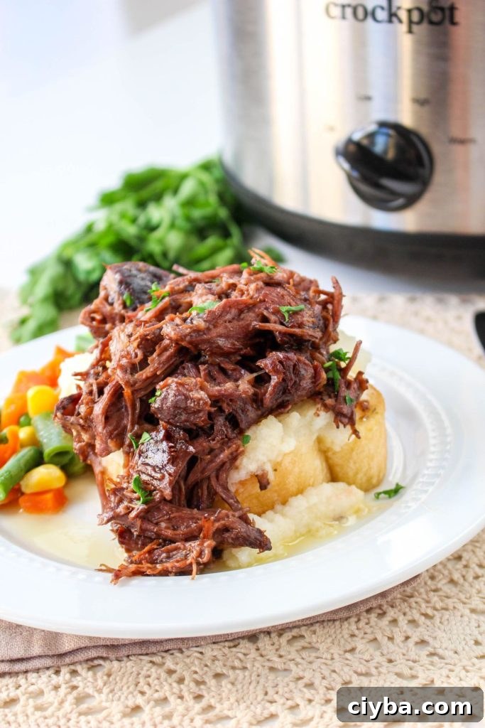 beef manhattan on a white plate with a side of cooked mixed vegetables