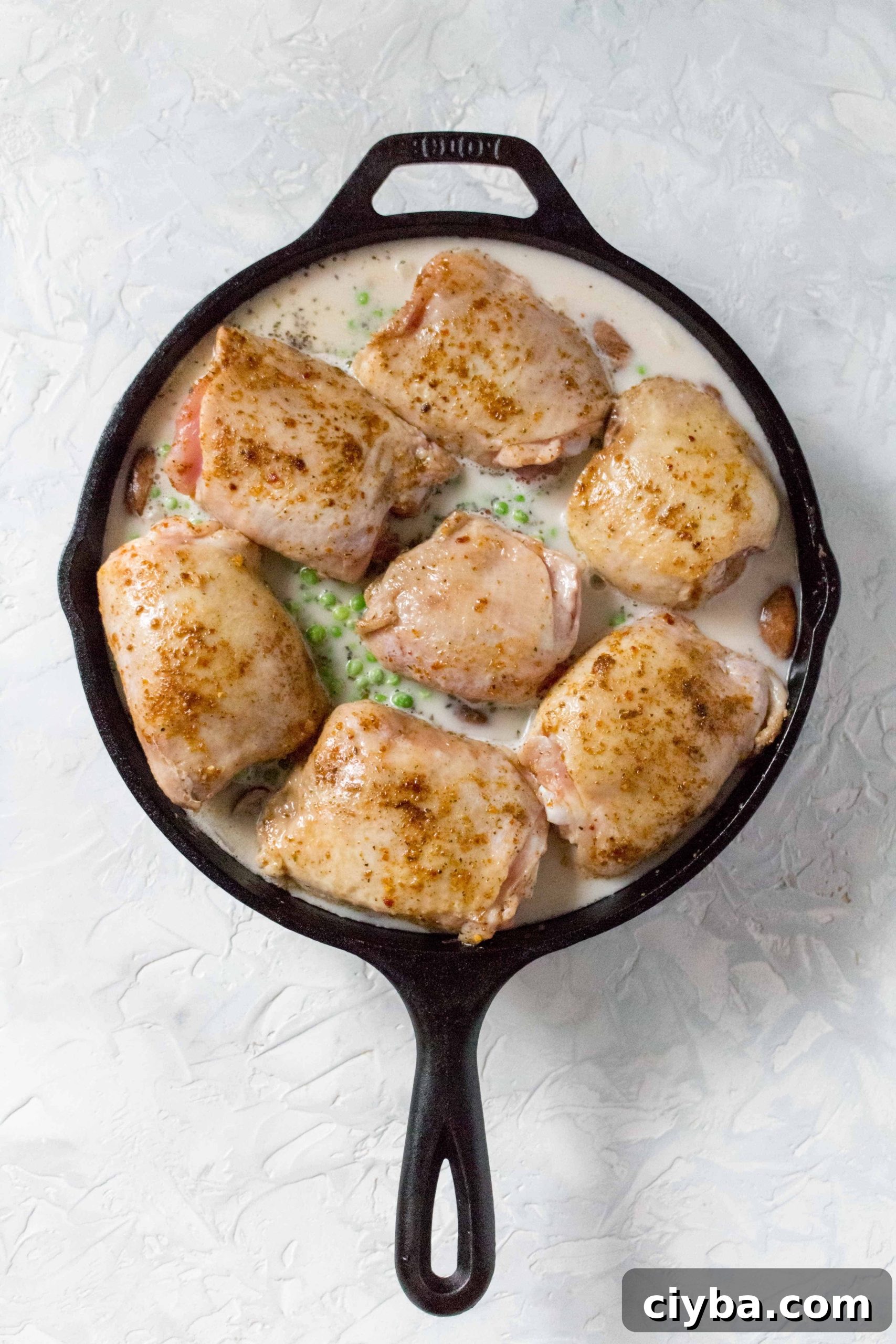 Place a lid (or tin foil) onto the cast iron and bake for 35 minutes. After, remove the lid (or tin foil) and bake for 10 more minutes. Broiling near the end if you prefer extra crispy skin.