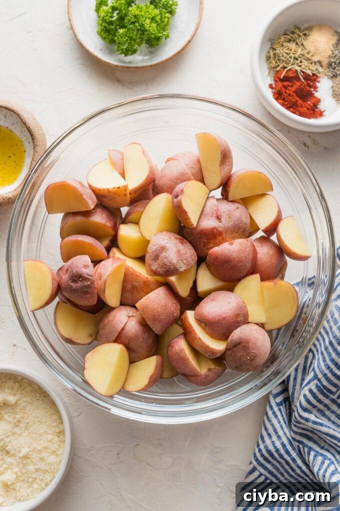 Crispy Parmesan-Crusted Red Potatoes for Dinner 4 Quartered baby red potatoes in a clear glass prep bowl.