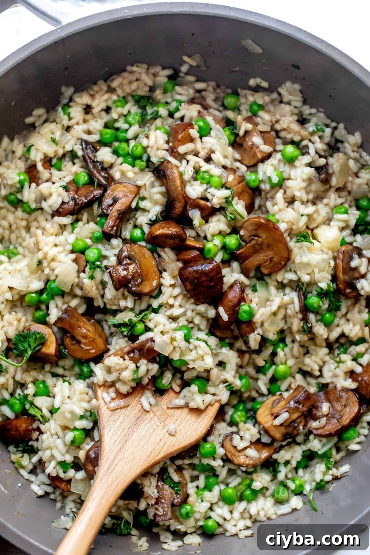 An overhead image of mushroom pea risotto in a skillet, ready to serve.