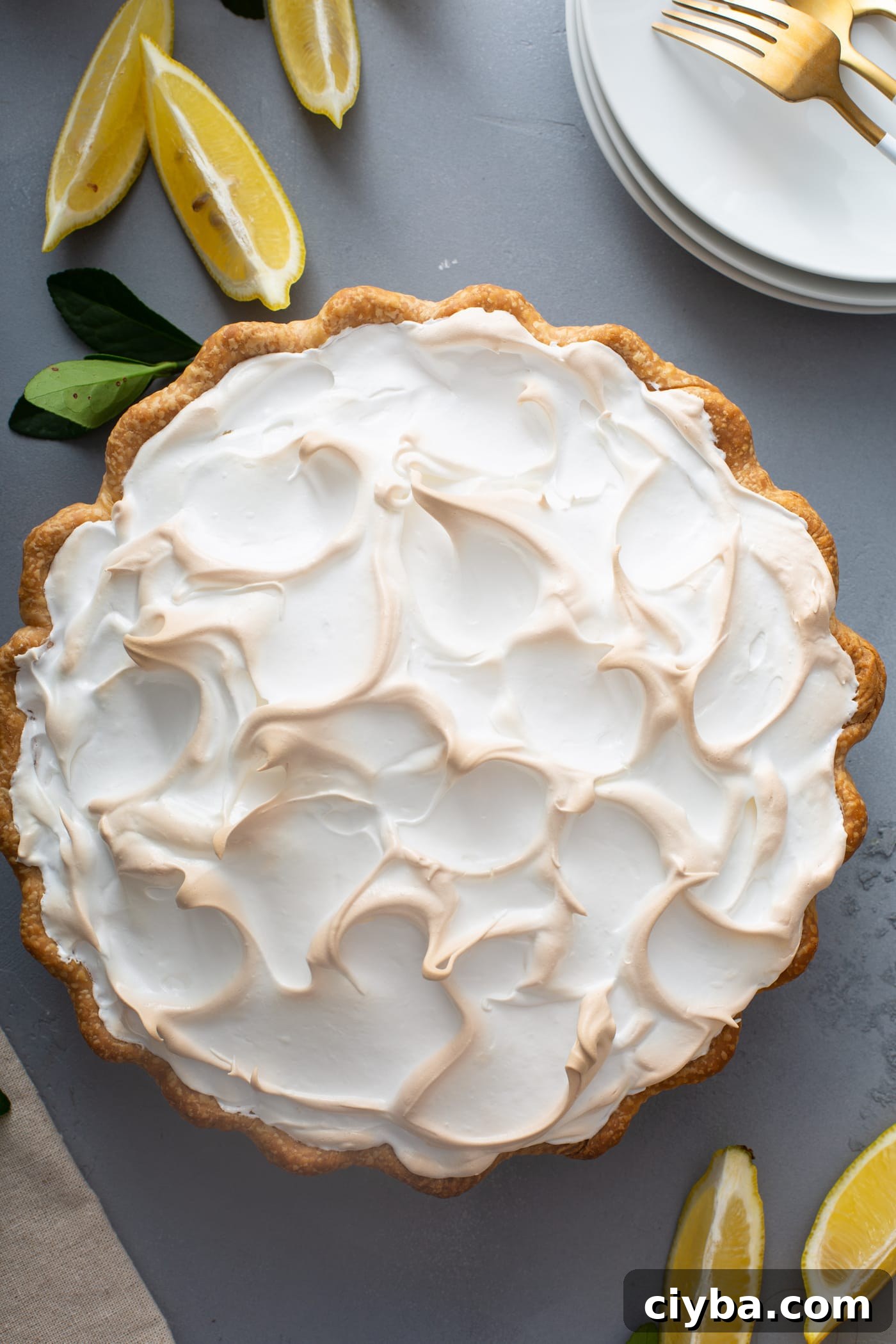 Top view of lemon meringue pie with lemon wedges
