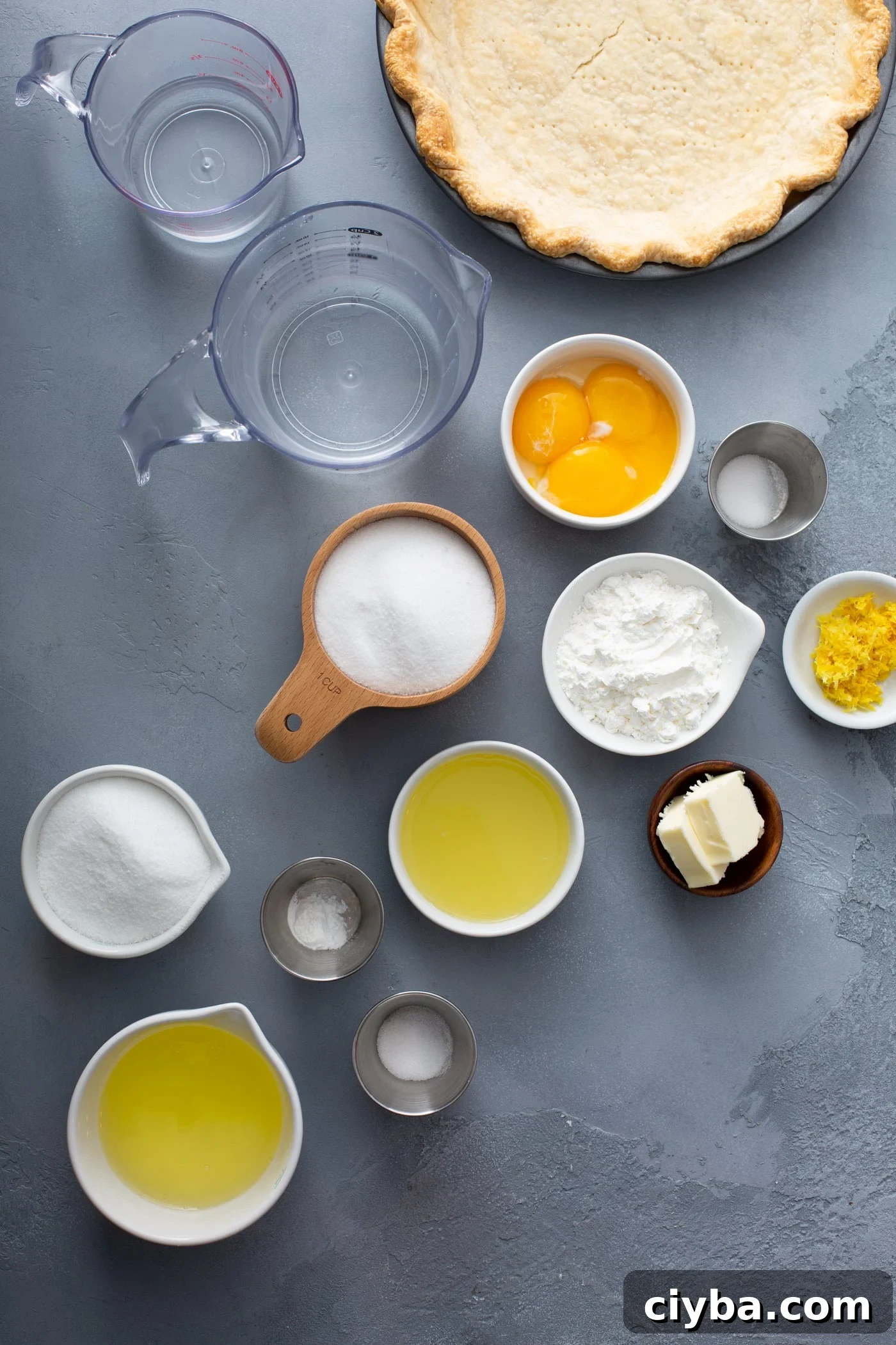 Measuring cups with ingredients for lemon meringue pie