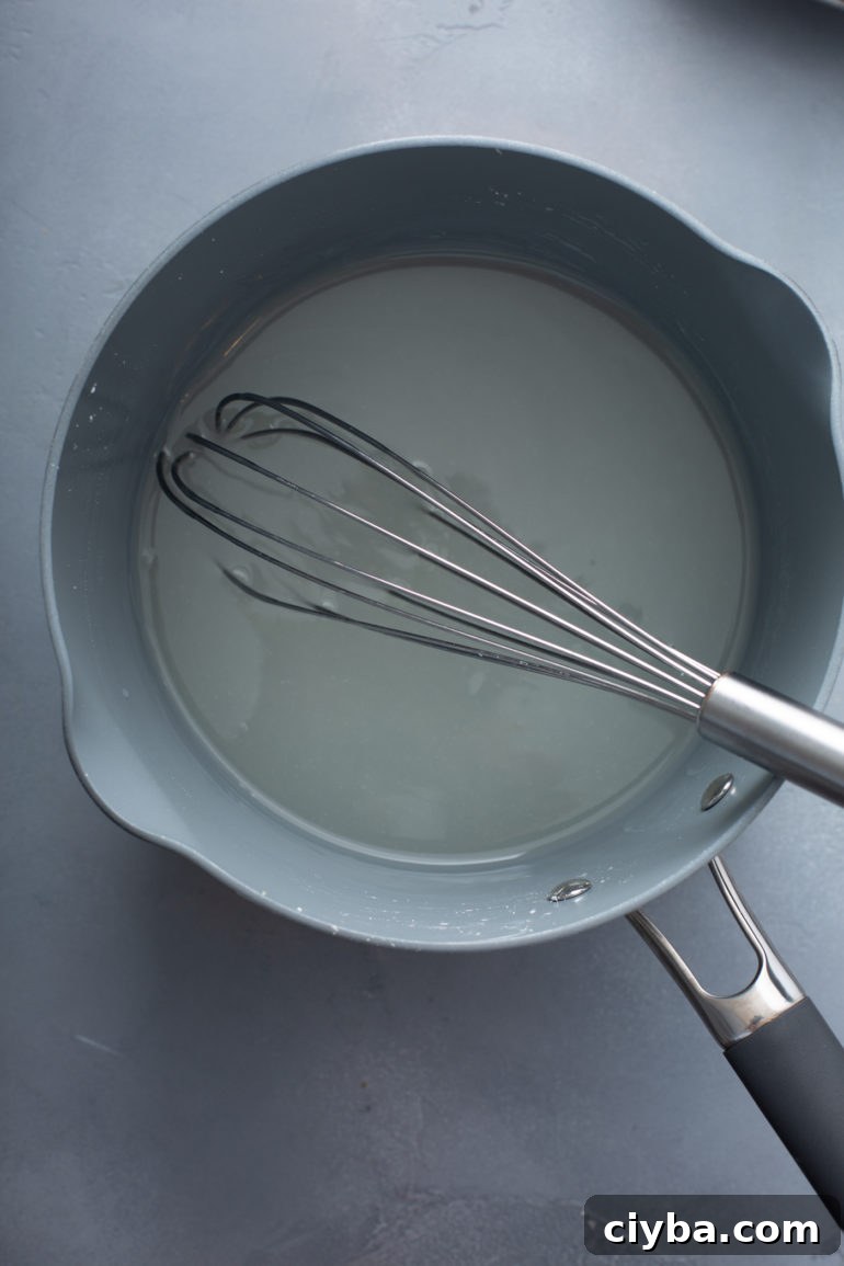 Saucepan with thickening lemon filling and a whisk