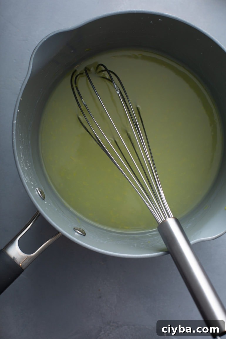 Lemon pie filling in a saucepan with a whisk