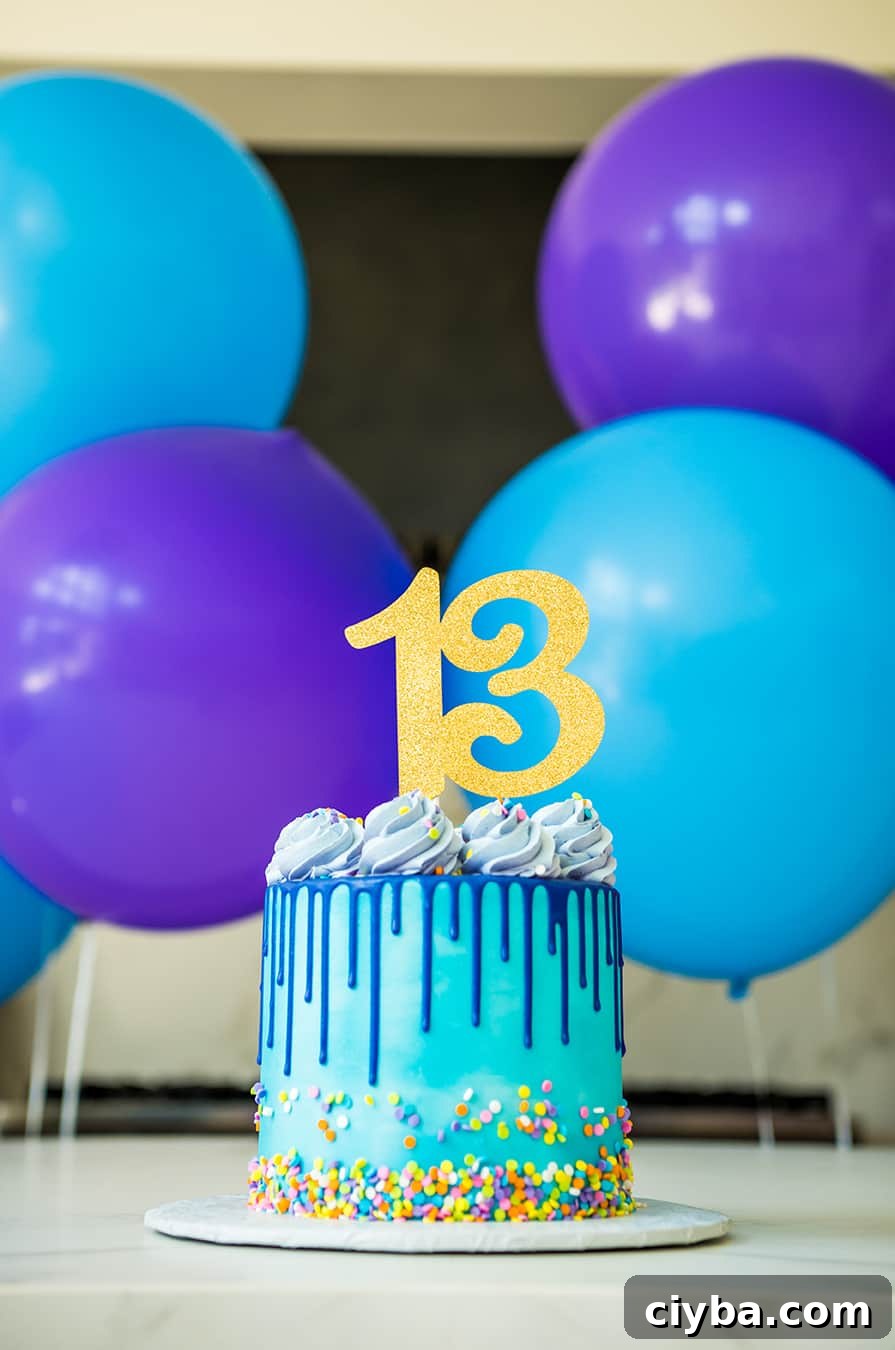 A blue and purple drip cake with sprinkles