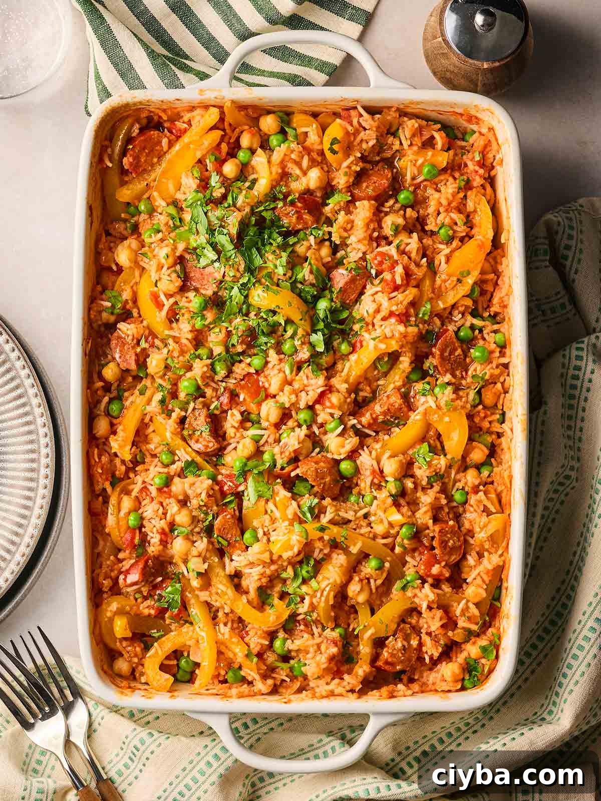 One-Pan Chorizo and Rice Bake: Dump, Bake, Serve 2 A table with a baked Chorizo and Rice in an oven dish, ready to serve onto plates.