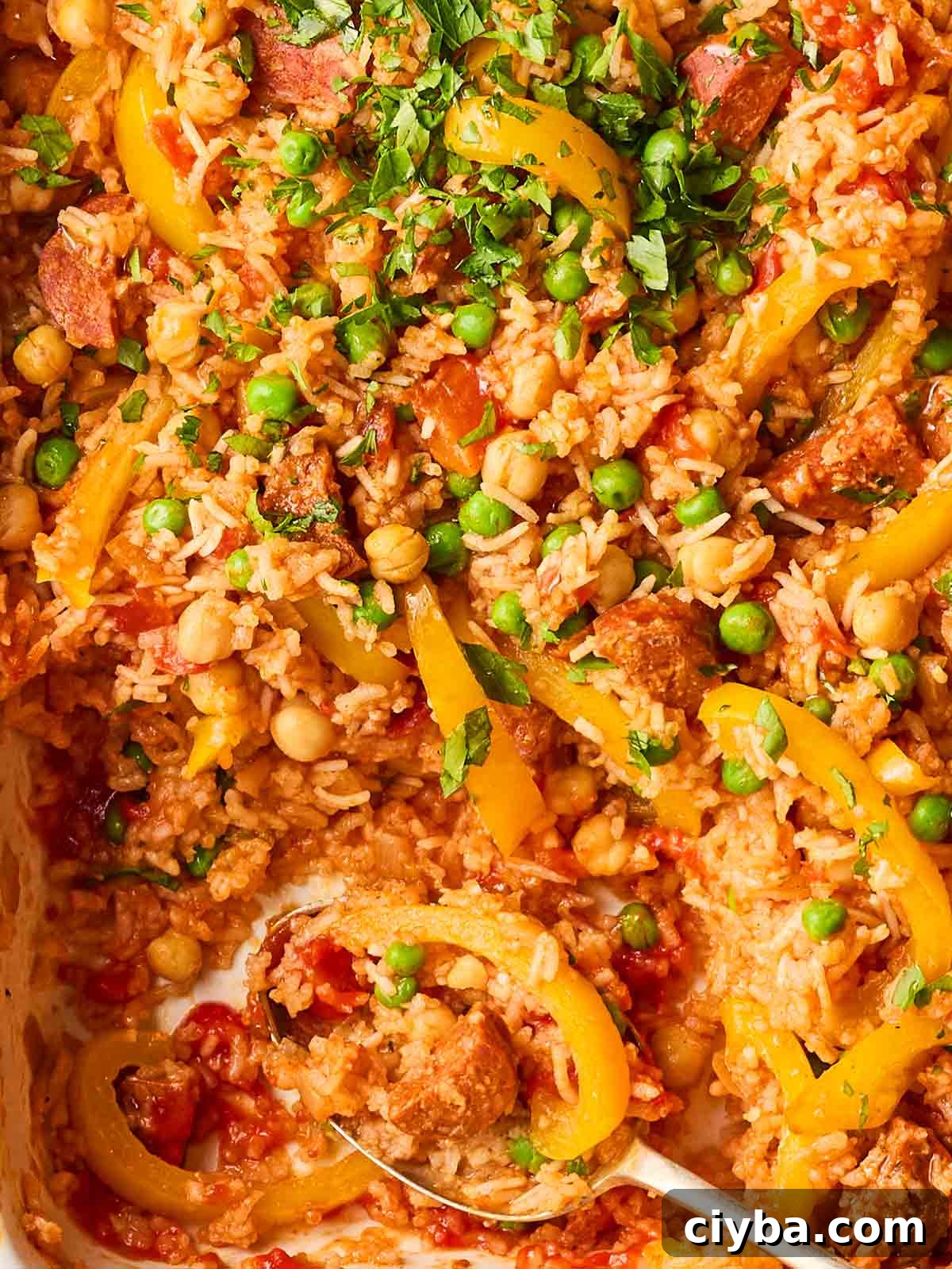 One-Pan Chorizo and Rice Bake: Dump, Bake, Serve 3 A close up of baked rice with chorizo, peppers, chickpeas and peppers.