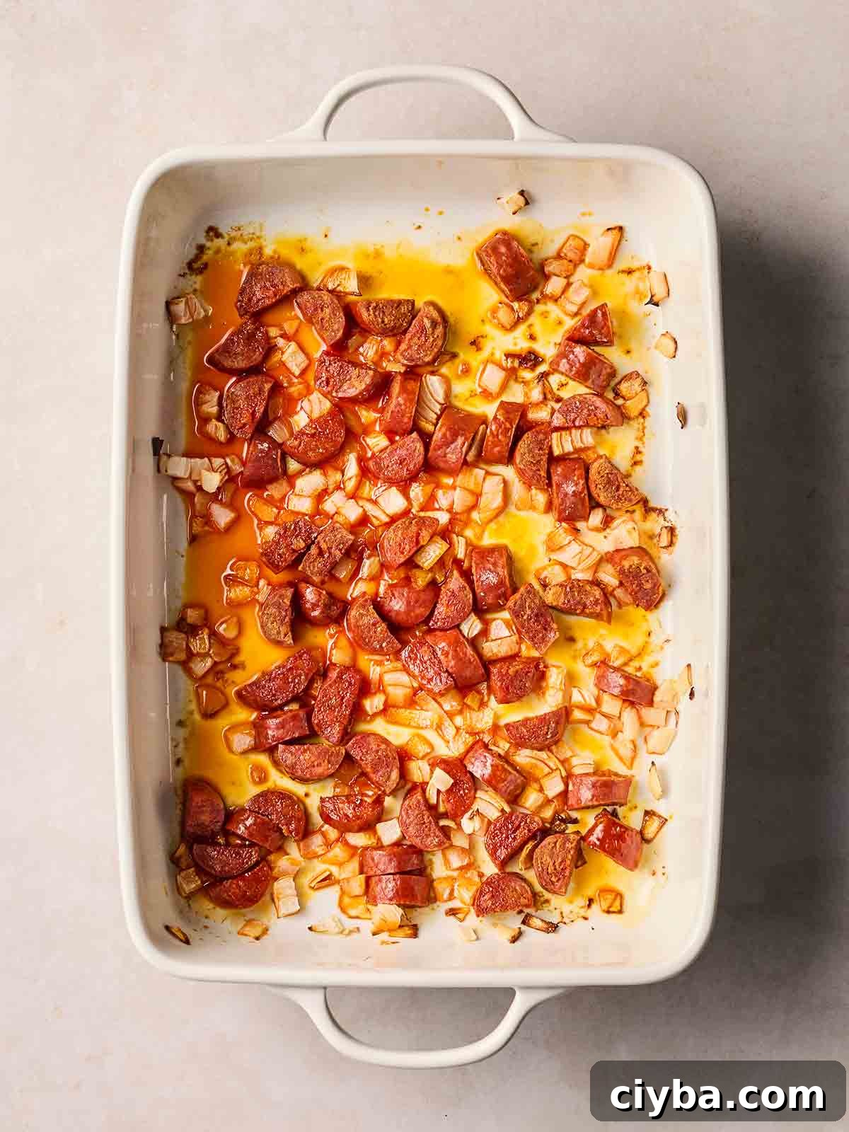 One-Pan Chorizo and Rice Bake: Dump, Bake, Serve 5 An oven dishwasher with sliced chorizo and onion, having been baked a little so the oils have been released.