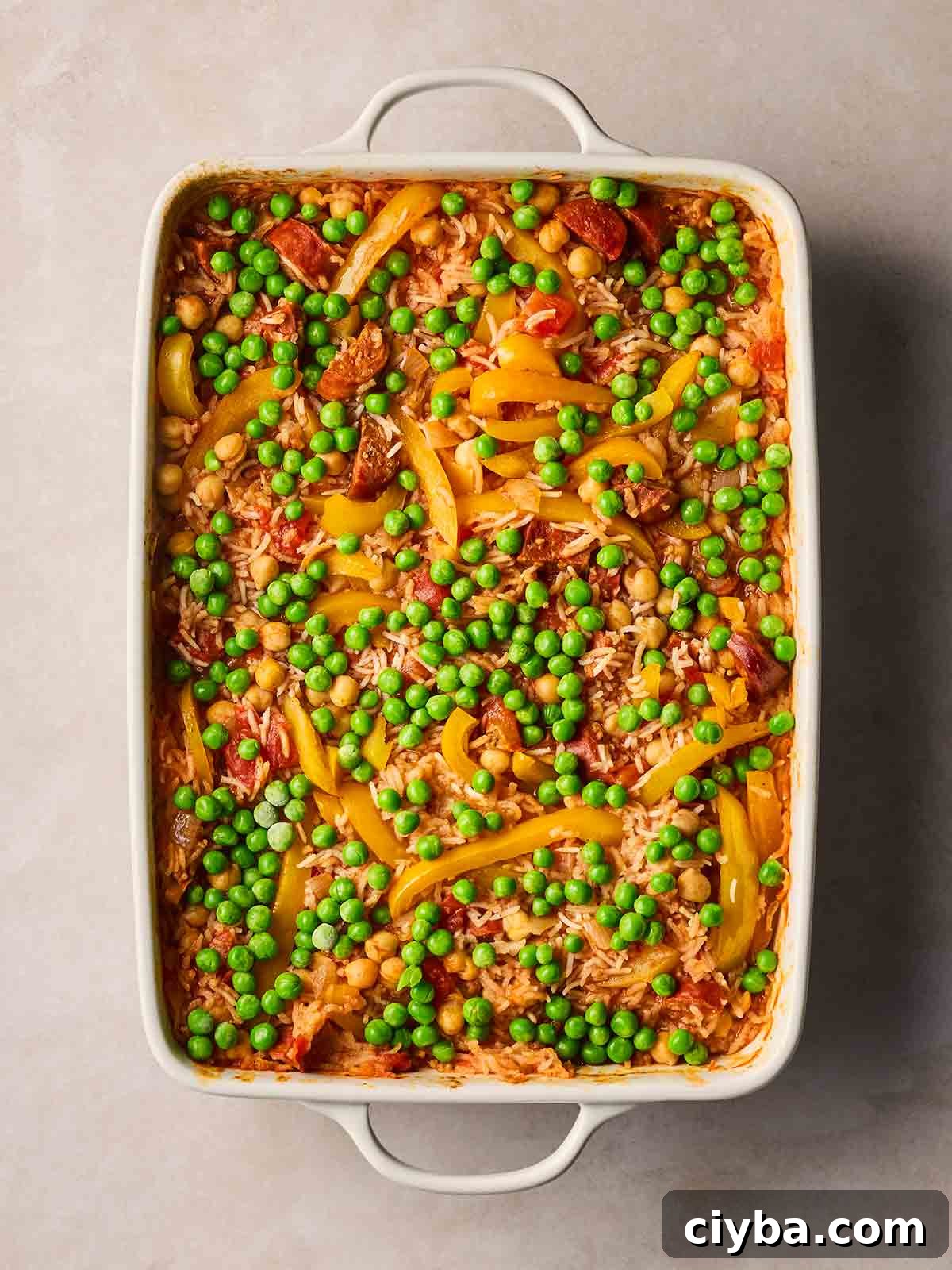 One-Pan Chorizo and Rice Bake: Dump, Bake, Serve 8 Frozen peas on top of a baked Chorizo and Rice dish, ready to go back in the oven to cook.