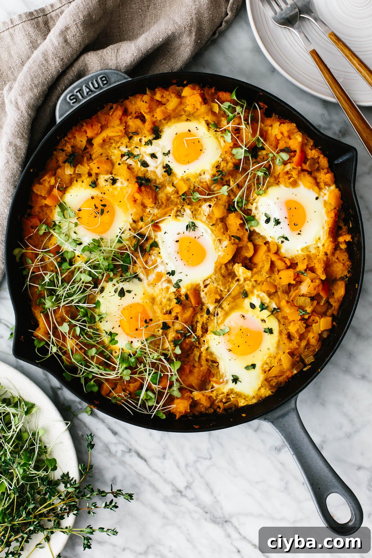 Orange shakshuka in a skillet on a table.