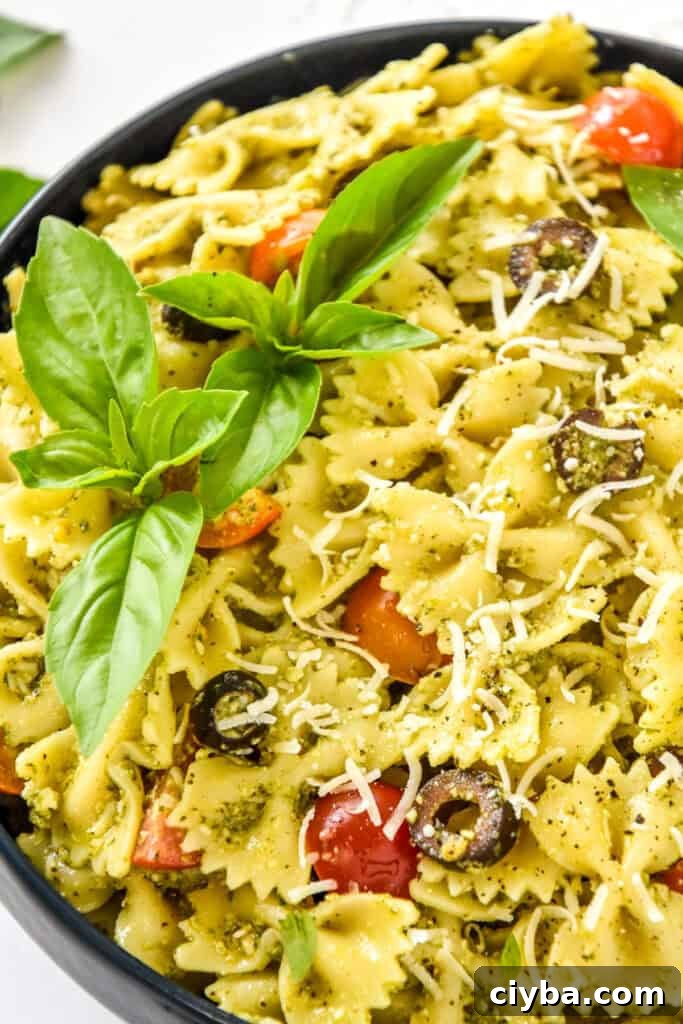 easy pesto pasta salad with fresh basil on top.