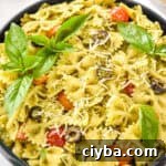 easy pesto pasta salad with fresh basil leaves on top.
