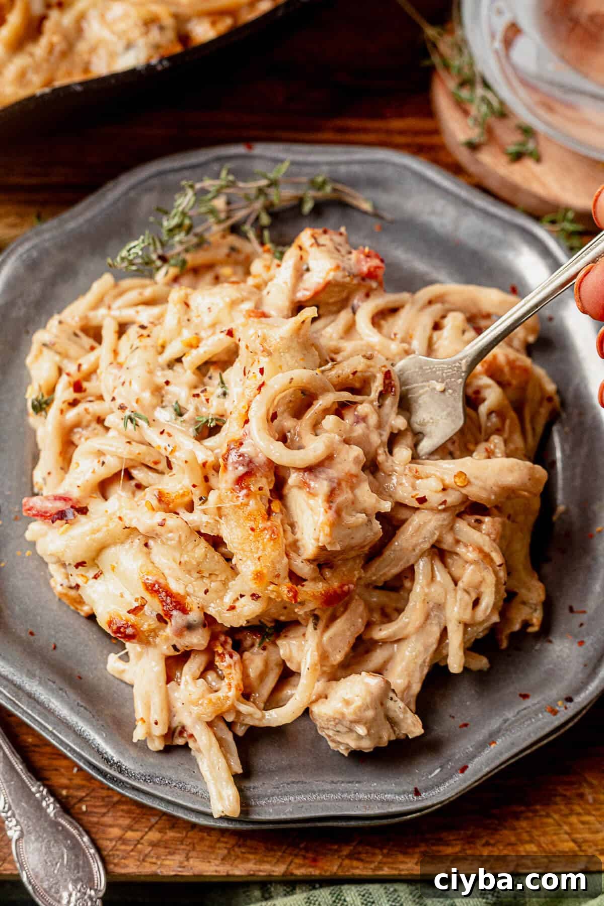 a fork in a plate of spaghetti chicken